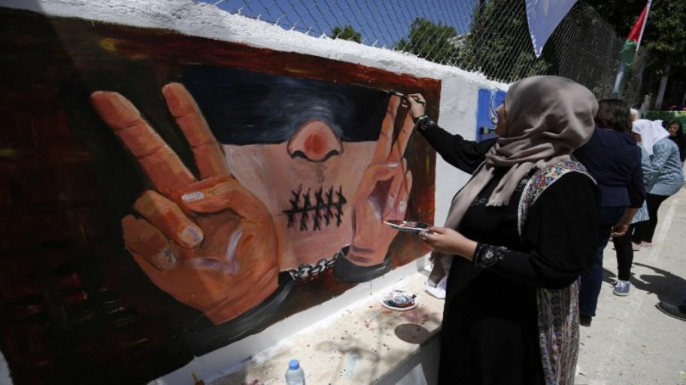 فلسطينية ترسم جدارية بمناسبة يوم الأسير الفلسطيني، 17 أبريل 2016. عباس مومني/ أ ف ب