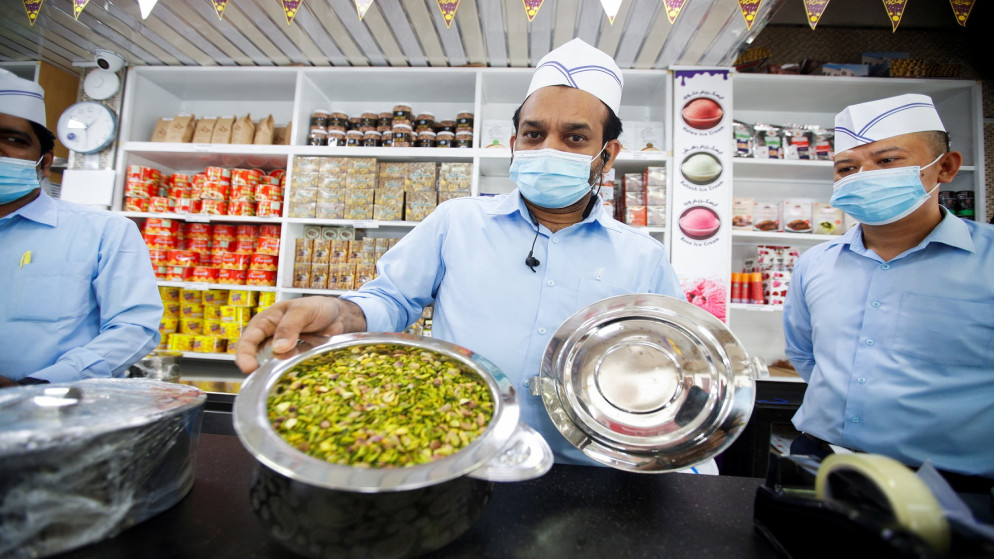 بائع يعرض "حلاوة" حلوى بحرينية تقليدية في محل حلويات حسين محمد شويطر في المحرق.(رويترز)