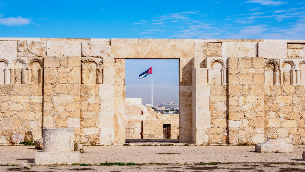 جبل القلعة في عمّان ويظهر علم الأردن من خلف البوابة. (shutterstock)