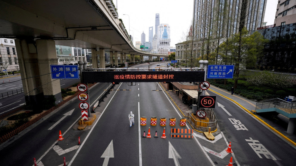 عامل يرتدي بدلة واقية يسير عند مدخل نفق يؤدي إلى منطقة بودونغ في شنغهاي، الصين، 28 آذار/مارس 2022. (رويترز)
