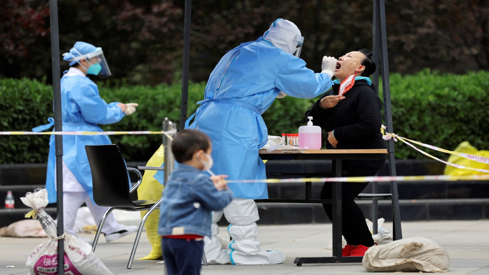 عامل طبي يرتدي بدلة واقية ويأخذ مسحة للكشف عن فيروس كورونا منطقة تشاويانغ في بكين، الصين، 10 أيار/ مايو 2022. (رويترز/ تينجشو وانغ)