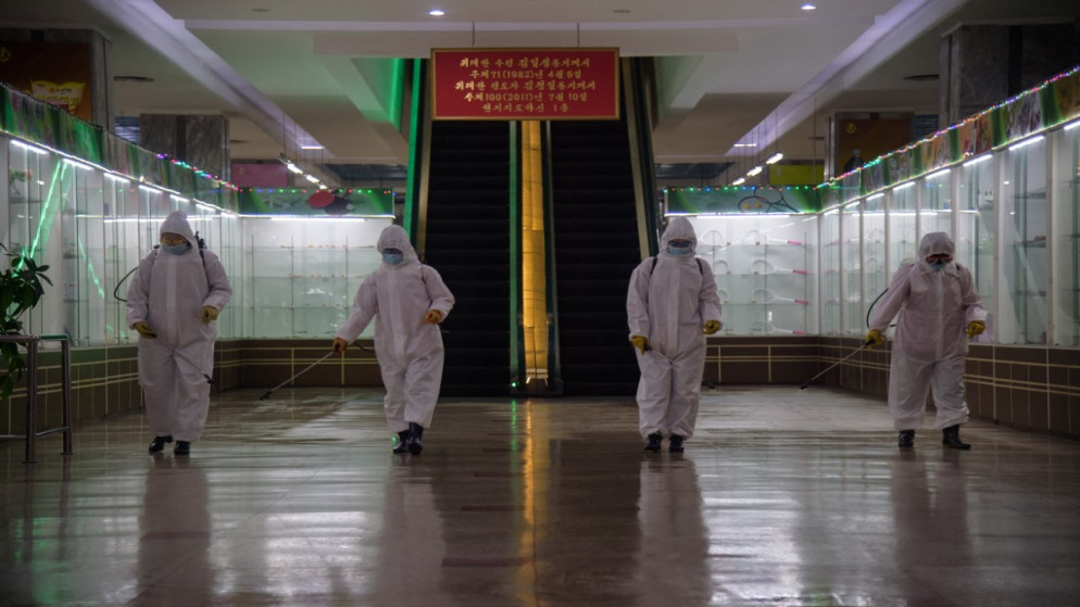 يقوم العاملون الصحيون برش مطهر داخل متجر بيونغ يانغ متعدد الأقسام رقم 1 قبل الافتتاح للعمل، في كوريا الشمالية. (أ ف ب)