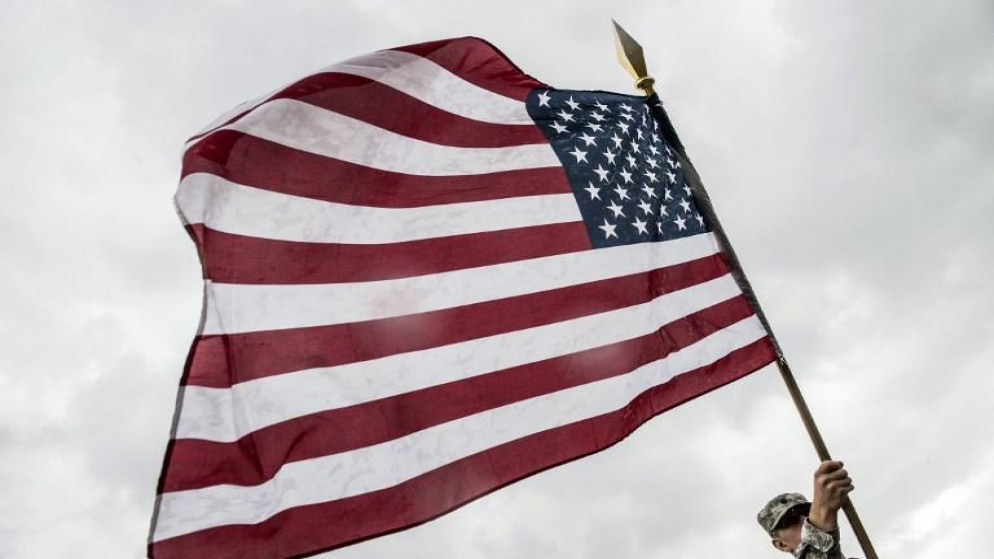 فرد من القوات الأميركية يحمل علم الولايات المتحدة الأميركية. (أ ف ب)