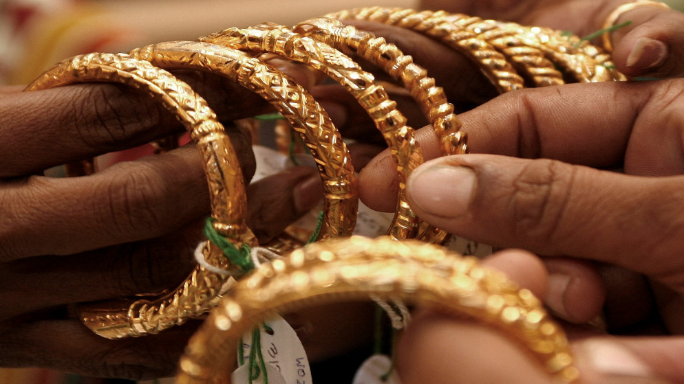 امرأة تحمل أساور ذهبية في متجر للمجوهرات في مدينة كولكاتا شرقي الهند. 14 أكتوبر/ تشرين الأول 2009. (رويترز)