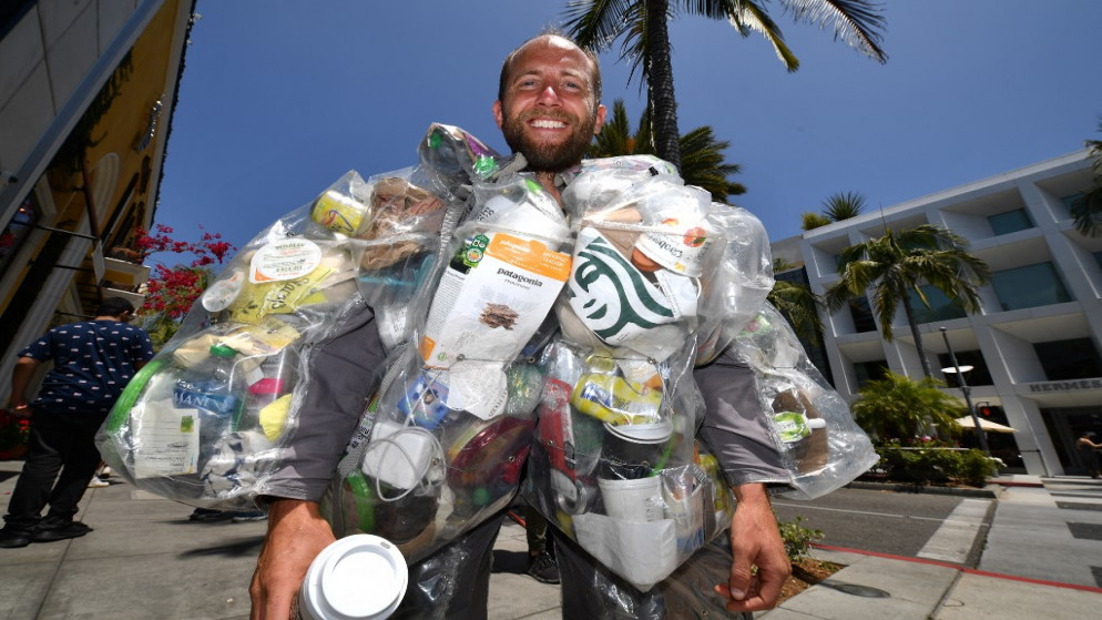 الناشط البيئي روب غرينفيلد يقف في منطقة بيفرلي هيلز الأميركية، كاليفورنيا، مرتديًا بدلة مليئة بكل قطعة قمامة وجدها خلال شهر واحد لرفع مستوى الوعي حول كمية القمامة التي يولدها شخص واحد فقط.16 مايو 2022.(أ ف ب)