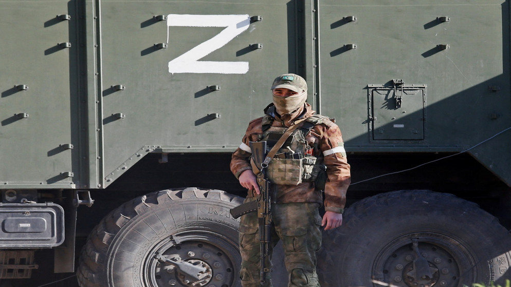 جندي روسي يقف بجانب مركبة عسكرية في مدينة ماريوبول الساحلية الجنوبية، أوكرانيا ، 20 نسيان/أبريل 2022. (رويتر)