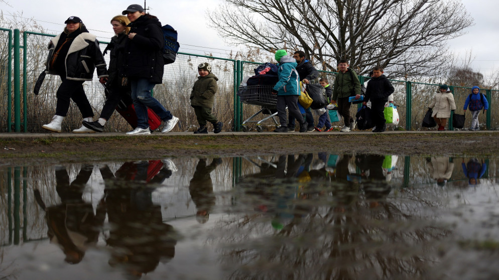 لاجئون أوكرانيون يعبرون الحدود الأوكرانية باتجاه بولندا. (رويترز)