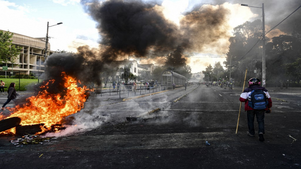 حريق يسد طريقًا أثناء الاشتباكات بين المتظاهرين والشرطة في كيتو .23 يونيو 2022 . (أ ف ب)