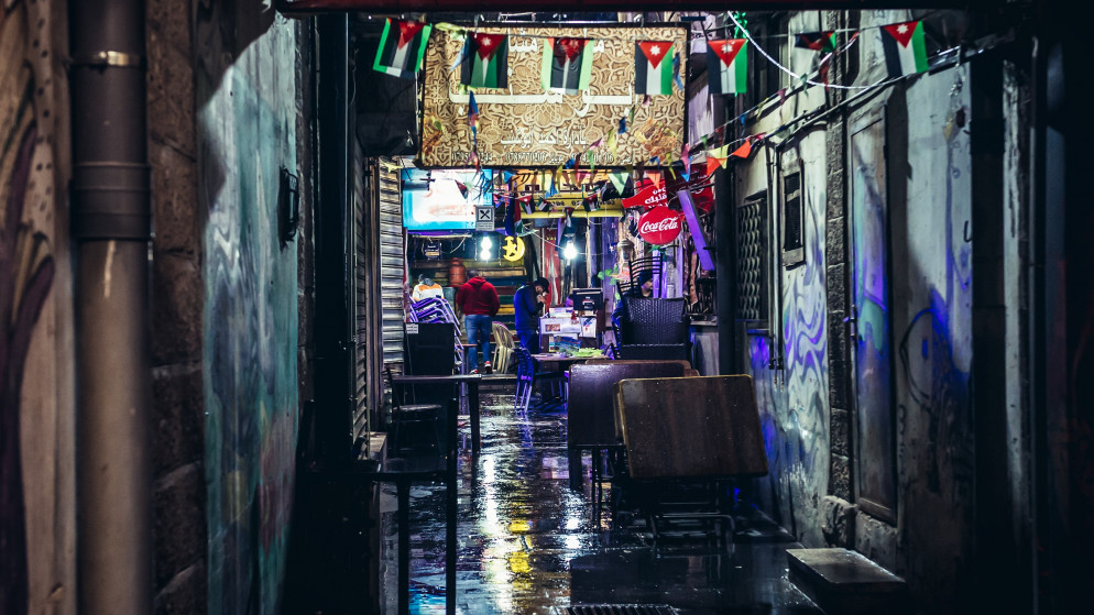 طاولات تعود لمطعم في زقاق في منطقة وسط البلد في عمّان. (shutterstock)