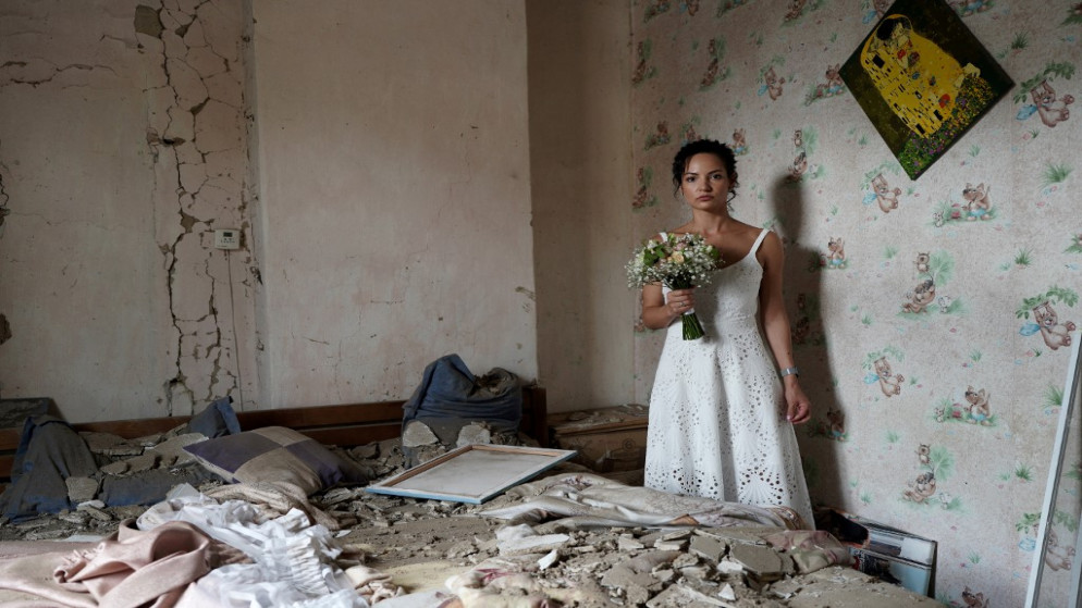 داريا ستينيوكوفا (31 عاما) وهي مدربة يوغا تلتقط صورة زفاف في شقتها التي تعرضت للقصف في فينيتسا في أوكرانيا. (أ ف ب)
