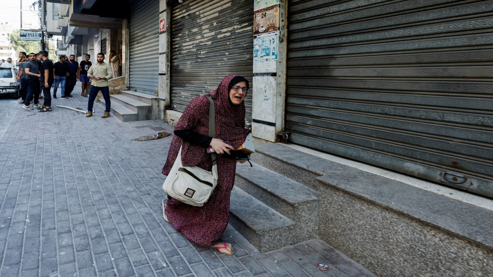 امرأة فلسطينية في الشارع بعد قصف إسرائيلي على مدينة غزة، 5 آب/أغسطس 2022. (رويترز)