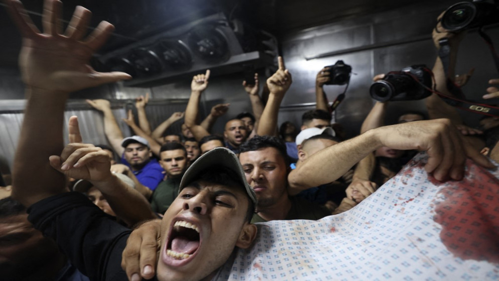 فلسطينيون ينقلون جثة شهيد من ضحايا غارة جوية إسرائيلية على مدينة غزة، من مشرحة مستشفى الشفاء، 5 أغسطس/آب 2022. (أ ف ب)