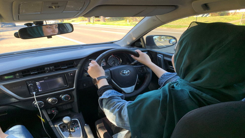 سحر عزيزي اللاجئة الأفغانية الوافدة حديثًا تقود سيارة خلال درسها الثاني في القيادة في سيدني في أستراليا .2 أغسطس 2022. (رويترز / ستيفيكا نيكول بايكس)