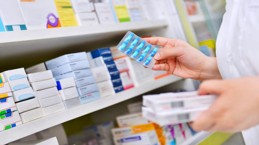 صورة توضيحية لصيدلانية تحمل أدوية في صيدلية. (shutterstock)