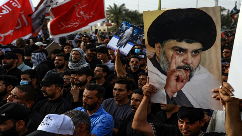 أنصار رجل الدين الشيعي مقتدى الصدر يحملون صوراً له أثناء تجمعهم في مدينة الناصرية بمحافظة ذي قار جنوبي العراق. 12/08/2022. ((أسعد نيازي / أ ف ب)