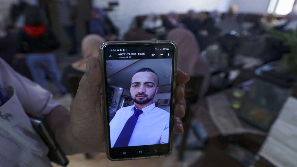 شخص يعرض على هاتفه المحمول صورة الشهيد محمد الشهام، 15 آب/أغسطس 2022. (أ ف ب)