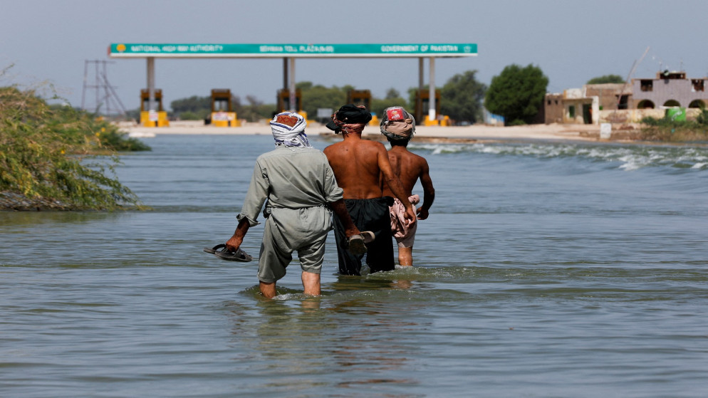 نازحون يسيرون على طريق سريع غمرته الفيضانات بعد هطول الأمطار والفيضانات خلال موسم الرياح الموسمية في سهوان ، باكستان ، 16 سبتمبر / أيلول 2022. (رويترز / أختار سومرو)
