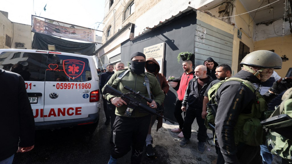 فلسطينيون يتجمعون حول سيارة إسعاف بعد غارة شنتها قوات الاحتلال الإسرائيلي على مخيم جنين للاجئين في الضفة الغربية . 26 كانون الثاني/ يناير ، 2023.(أ ف ب)