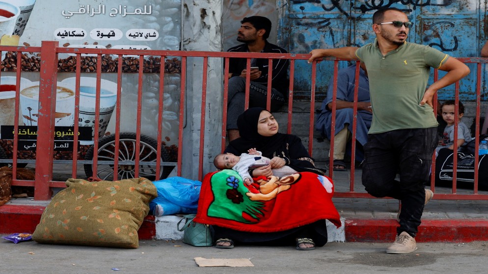 فلسطينية تحمل طفلها أثناء نزوحها من شمال قطاع غزة إلى جنوبه. 9 نوفمبر، 2023. (رويترز)