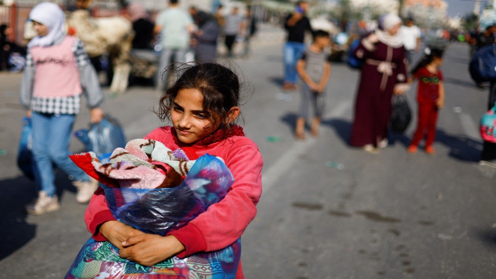 فتاة فلسينية تحمل حقيبة أثناء نزوحها مع عائلات من شما قطاع غزة إلى جنوبه. 9 نوفمبر، 2023. (رويترز)