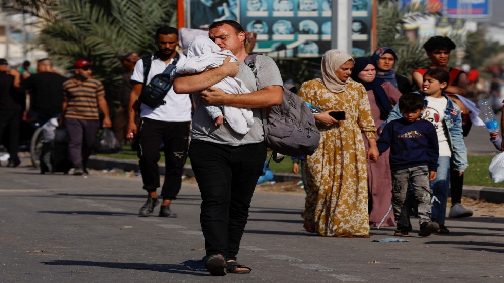 رجل يحمل طفلته على كتفيه  اثناء نزوحهم من شمال غزة يتجهون نحو الجنوب. 9 نوفمبر، 2023. (رويترز)
