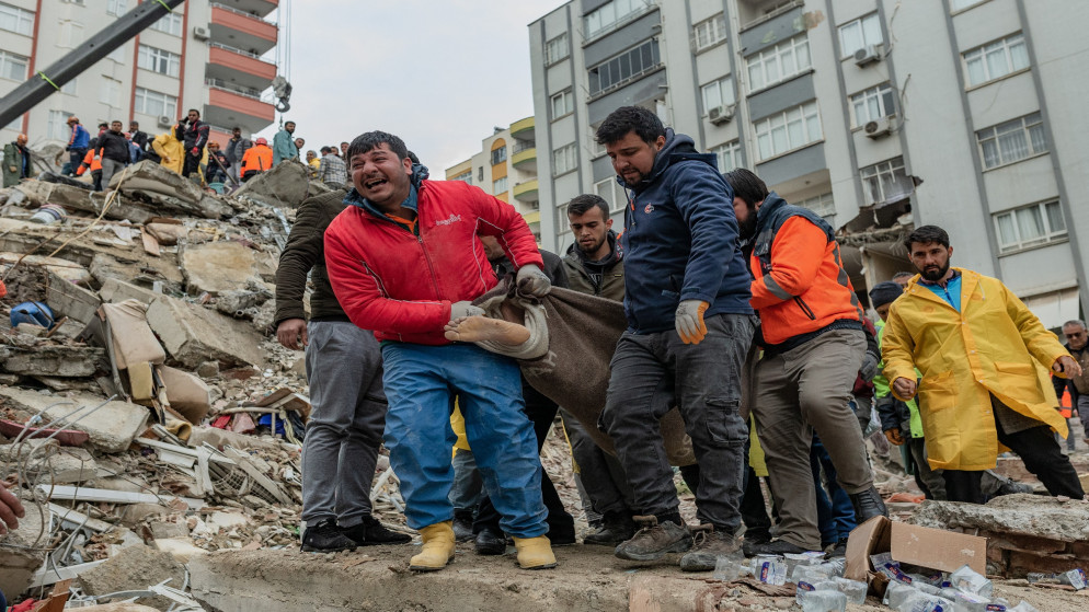 عمال الإنقاذ يحملون جثة عثر عليها تحت الأنقاض في أضنة التركية، 6 شباط/فبراير 2023. (أ ف ب)