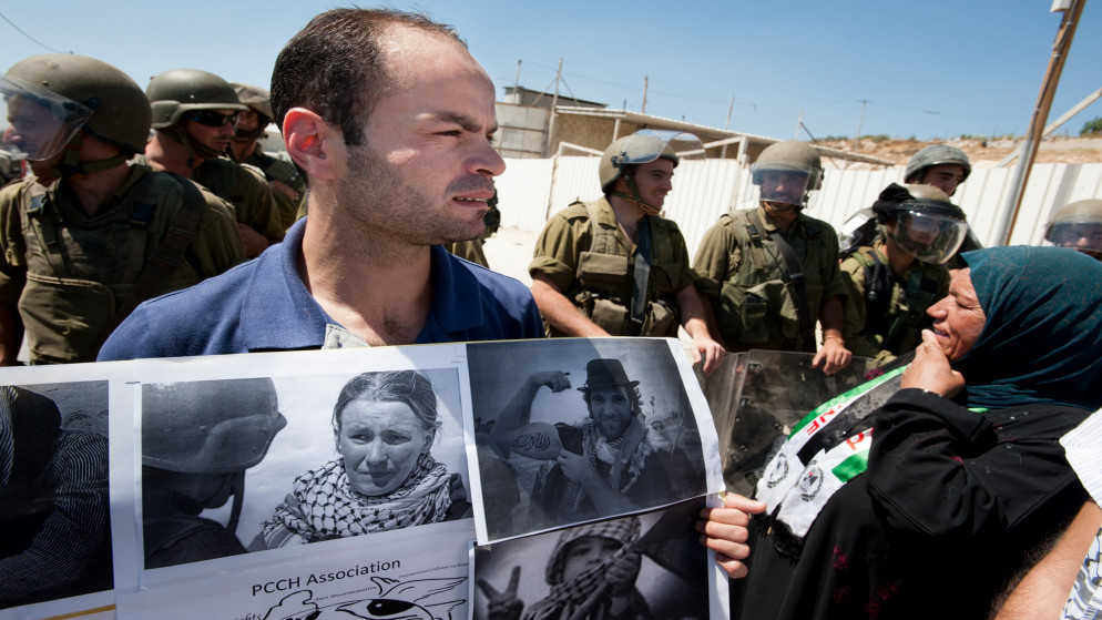 صورة أرشيفية لمظاهرة ضد الجدار العازل الإسرائيلي في الضفة الغربية يحمل فيها أحد المشاركين لافتة تضم صورة الراحلة راشيل كوري التي قتلت تحت جرافة إسرائيلية في غزة في 2003. (istockphoto)