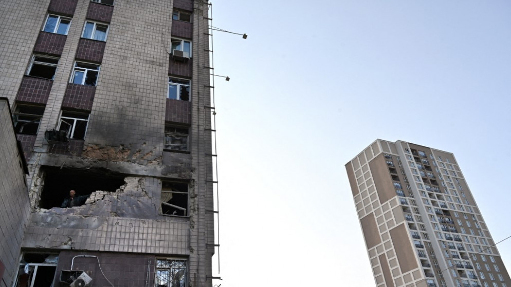 أحد السكان المحليين ينظر إلى مبنى سكني مدمر جزئيًا بعد غارة ضخمة بطائرات بدون طيار استهدفت بشكل أساسي العاصمة الأوكرانية، في كييف .28 مايو 2023. (أ ف ب)