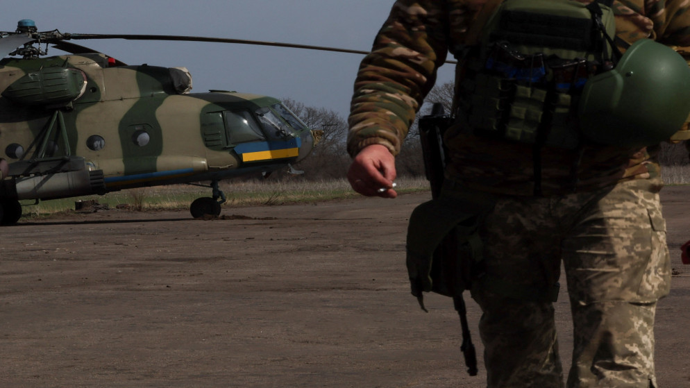 عنصر في الجيش الأوكراني قرب مروحية عسكرية في دونيتسك. (رويترز)